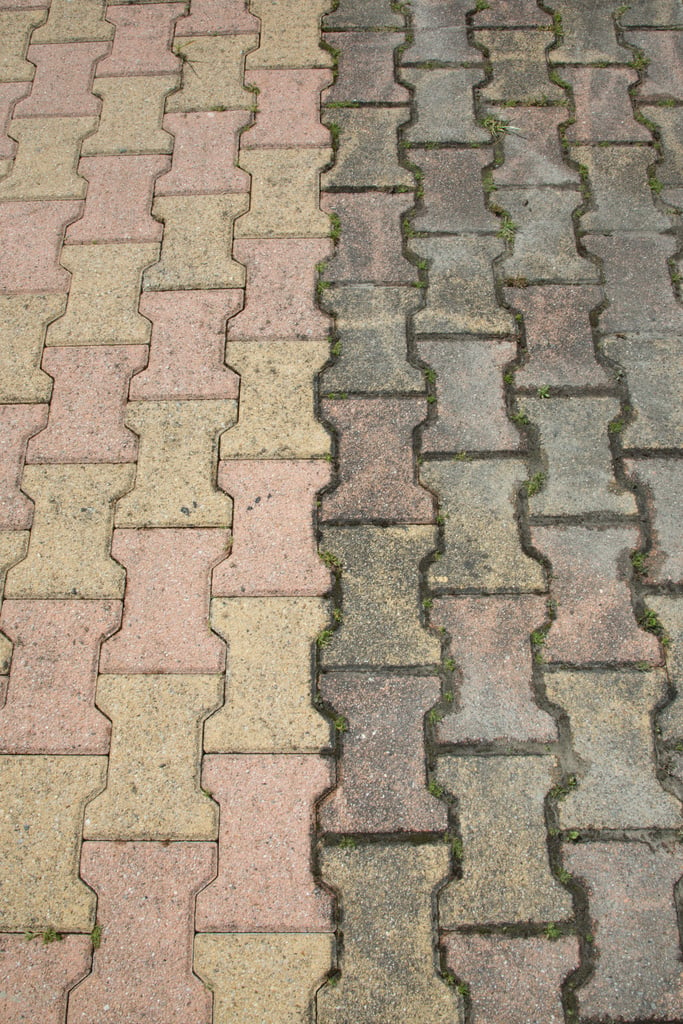 Contrast between patio paving slabs which have been pressured washed before and after cleaning